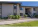 Well-maintained building exterior features manicured landscaping, mature trees, and a convenient staircase at 1402 E Guadalupe Rd # 122, Tempe, AZ 85283