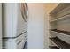 Convenient laundry closet features a stacked washer and dryer set next to shelving at 1402 E Guadalupe Rd # 122, Tempe, AZ 85283