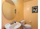 Cozy powder room featuring a round mirror and bright yellow walls at 14186 N 100Th Pl, Scottsdale, AZ 85260
