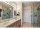 Bathroom with double sink vanity, large mirror, and glass-enclosed shower at 14186 N 100Th Pl, Scottsdale, AZ 85260