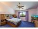Spacious main bedroom featuring a large window, ceiling fan and tv at 14186 N 100Th Pl, Scottsdale, AZ 85260