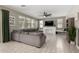 Comfortable living room featuring a gray sectional sofa, modern fireplace, and neutral-toned decor at 20926 E Longwood Dr, Queen Creek, AZ 85142