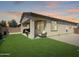 Well-maintained backyard featuring green grass, a covered patio area with comfortable seating, and desert landscaping at 24776 N 171St Ln, Surprise, AZ 85387