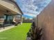 Lush backyard featuring artificial grass, desert plants, and a covered patio perfect for outdoor relaxation and entertainment at 24776 N 171St Ln, Surprise, AZ 85387