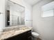 Bright bathroom with a granite vanity, tiled flooring, a framed mirror, and ample natural light at 24776 N 171St Ln, Surprise, AZ 85387