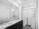 Bright bathroom featuring double sinks with granite countertops, and a tiled glass-enclosed shower at 24776 N 171St Ln, Surprise, AZ 85387