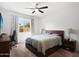 Cozy bedroom with carpet, ceiling fan, and a window showcasing the pleasant backyard view at 24776 N 171St Ln, Surprise, AZ 85387