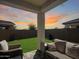 Relaxing covered patio with comfortable outdoor seating, overlooking a well-manicured backyard with lush green grass at 24776 N 171St Ln, Surprise, AZ 85387