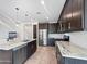 Modern kitchen featuring stainless steel appliances, granite countertops, tiled flooring, and dark wood cabinetry at 24776 N 171St Ln, Surprise, AZ 85387