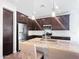 Well-lit kitchen boasts stainless appliances, a granite island with seating, and stylish dark wood cabinets at 24776 N 171St Ln, Surprise, AZ 85387
