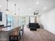 Open-concept living area featuring granite countertop bar, carpet floors, and access to the backyard patio at 24776 N 171St Ln, Surprise, AZ 85387