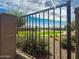 View through a metal gate showcases a well-maintained neighborhood with desert landscaping and charming single-Gathering homes at 24776 N 171St Ln, Surprise, AZ 85387