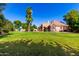 Expansive backyard with lush lawn, mature trees, and a play area, offering ample outdoor space at 2558 E Page Ct, Gilbert, AZ 85234