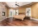 Bright bedroom featuring hardwood floors, a cozy fireplace, private outdoor access, and plantation shutters at 2558 E Page Ct, Gilbert, AZ 85234