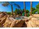 Rock-enclosed hot tub, a tranquil spot amidst landscaped surroundings, offering relaxation at 2558 E Page Ct, Gilbert, AZ 85234