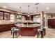 Gourmet kitchen featuring a large island, stone accents, stainless steel appliances, and warm pendant lighting at 2558 E Page Ct, Gilbert, AZ 85234