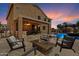 This backyard has a stone fire pit, outdoor seating, a bar, and a swimming pool at 25818 N 68Th Ave, Peoria, AZ 85383
