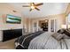 A TV adorns the wall in this bedroom, which features a sitting room through a glass door at 25818 N 68Th Ave, Peoria, AZ 85383