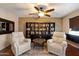 A sitting room offers two lounge chairs, a ceiling fan, and a built-in bookcase at 25818 N 68Th Ave, Peoria, AZ 85383