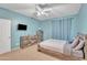 Bedroom with blue walls features a wooden bed, TV, ceiling fan, and matching dressers at 2642 S Joplin --, Mesa, AZ 85209