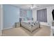Bright bedroom with blue accent wall, ceiling fan, and a cozy queen size bed at 2642 S Joplin --, Mesa, AZ 85209