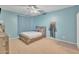 Light blue bedroom featuring a wooden bed, blue curtains, ceiling fan, and neutral carpet at 2642 S Joplin --, Mesa, AZ 85209