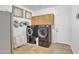 Convenient laundry room with front-load washer and dryer, ample cabinet space, and neutral tile flooring at 2642 S Joplin --, Mesa, AZ 85209