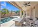 Covered patio showcasing a modern outdoor fire pit and a serene view of the landscaped backyard and pool at 2642 S Joplin --, Mesa, AZ 85209