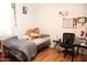 A cozy bedroom with a comfortable bed, study desk, and natural light from the window at 2718 W Montebello Ave, Phoenix, AZ 85017