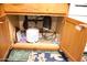 View inside of a sink base cabinet showing plumbing, garbage disposal, and water filtration at 2718 W Montebello Ave, Phoenix, AZ 85017