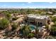 Aerial view of the property featuring a sparkling pool, desert landscaping, and a cozy outdoor living area at 27203 N 64Th Way, Scottsdale, AZ 85266