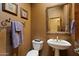 Charming powder room featuring a pedestal sink, ornate mirror, and warm, earthy tones at 27203 N 64Th Way, Scottsdale, AZ 85266