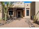 Inviting home front entrance with custom wood detailing, desert landscaping, and a charming seating area at 27203 N 64Th Way, Scottsdale, AZ 85266