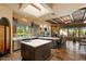 Modern kitchen with stone tile flooring, a central island, and an adjacent living area with a fireplace at 27203 N 64Th Way, Scottsdale, AZ 85266