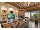 Rustic living room featuring a wood-beam ceiling, stone fireplace, and comfortable leather seating at 27203 N 64Th Way, Scottsdale, AZ 85266