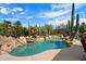 Beautiful pool area with lush landscaping, rock features, and clear blue water at 27203 N 64Th Way, Scottsdale, AZ 85266