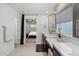 Bright bathroom featuring dual vanities, modern fixtures, and a doorway to the main bedroom at 29431 N 122Nd Gln, Peoria, AZ 85383