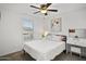 Cozy bedroom with a ceiling fan, plush bedding, and a well-lit vanity area at 29431 N 122Nd Gln, Peoria, AZ 85383
