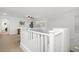 Upstairs hallway with white railing, carpet, and view into adjacent living space at 29431 N 122Nd Gln, Peoria, AZ 85383
