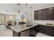 Open-concept kitchen with granite island, stainless appliances, and dark cabinets, seamlessly connected to the dining area at 29431 N 122Nd Gln, Peoria, AZ 85383
