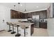 Contemporary kitchen boasts stainless steel appliances, a granite island with seating, and sleek, dark-stained cabinets at 29431 N 122Nd Gln, Peoria, AZ 85383