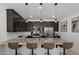 Modern kitchen with stainless steel appliances, granite counters, and dark cabinetry, complemented by stylish pendant lighting at 29431 N 122Nd Gln, Peoria, AZ 85383