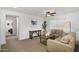 Cozy living room featuring neutral-toned furniture, a ceiling fan, and a large window for natural light at 29431 N 122Nd Gln, Peoria, AZ 85383