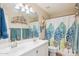 Well-lit bathroom featuring double sinks, modern vanity, white cabinets and a decorative shower curtain at 3133 E Redwood Ct, Phoenix, AZ 85048