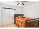 Bright bedroom with a ceiling fan and a comfy bed with orange and red diamond patterned comforter at 3133 E Redwood Ct, Phoenix, AZ 85048