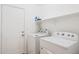 Clean laundry room with a white door, washer, dryer, shelf and an ironing board at 3133 E Redwood Ct, Phoenix, AZ 85048