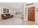 Inviting living room with tile flooring, a large window, and a classic wooden front door at 3133 E Redwood Ct, Phoenix, AZ 85048