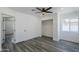 A well-lit bedroom with a ceiling fan, wood-look floors, a closet, and a door to another room at 346 W Edgemont Ave, Phoenix, AZ 85003