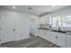 Kitchen featuring white cabinets, quartz countertops, and modern fixtures near the laundry and entry door at 346 W Edgemont Ave, Phoenix, AZ 85003