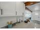 Bright kitchen featuring white cabinets, quartz countertops, and dark fixtures with a view to the living room at 346 W Edgemont Ave, Phoenix, AZ 85003